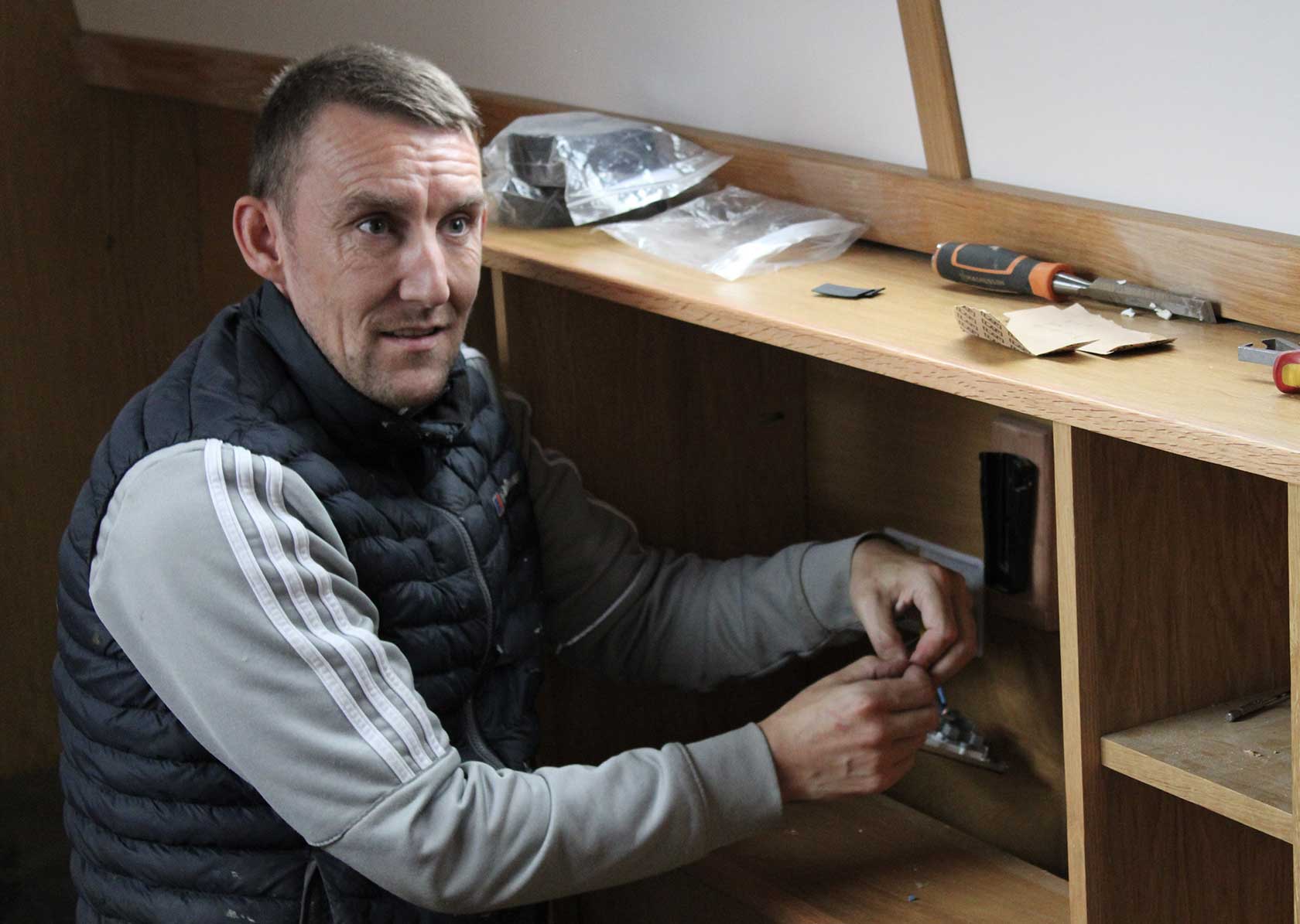 A man doing work on the inside of a narrowboat